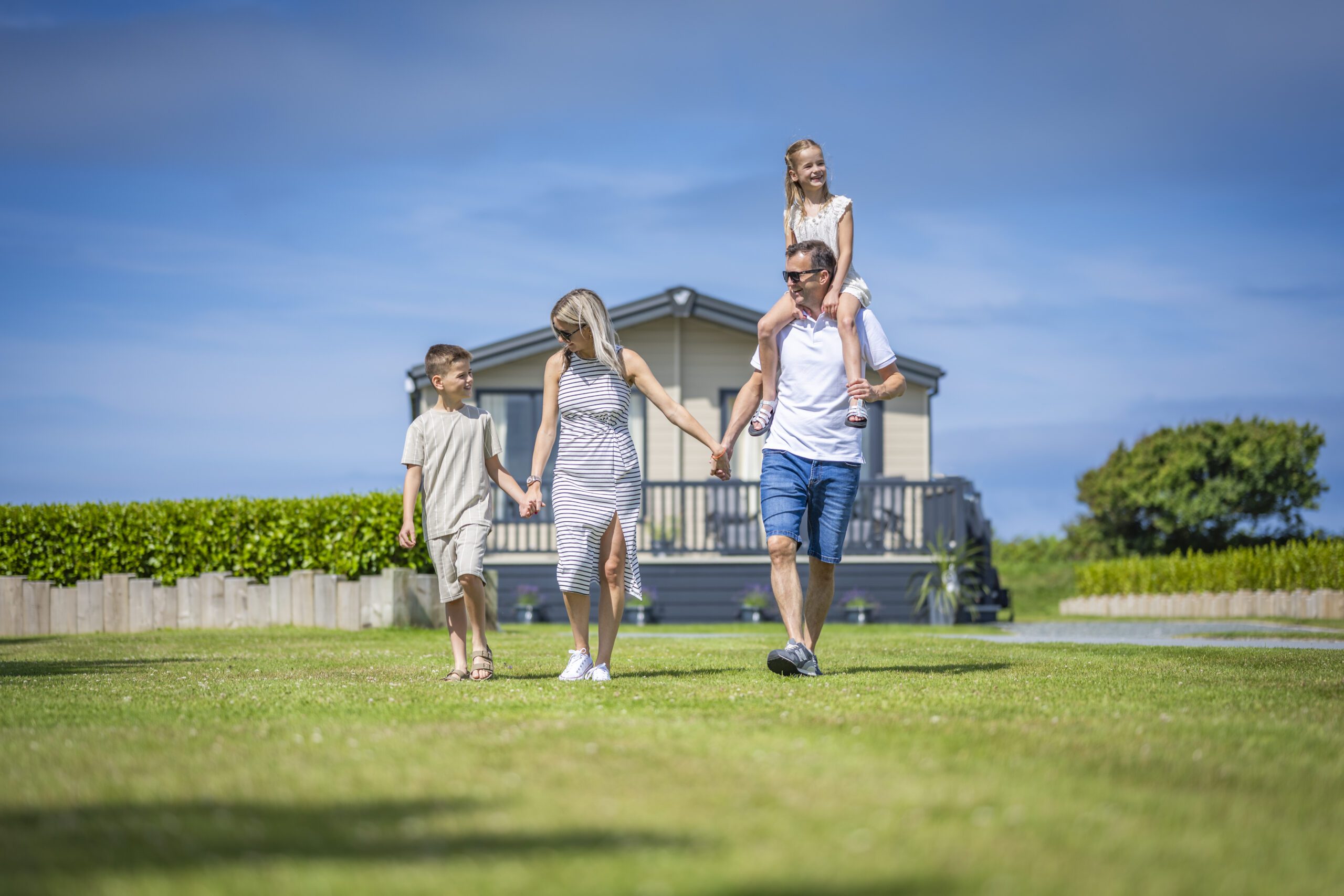 Familia descansando junto a un alojamiento de vacaciones en un parque Thornley / Family relaxing beside holiday accommodation at a Thornley park
