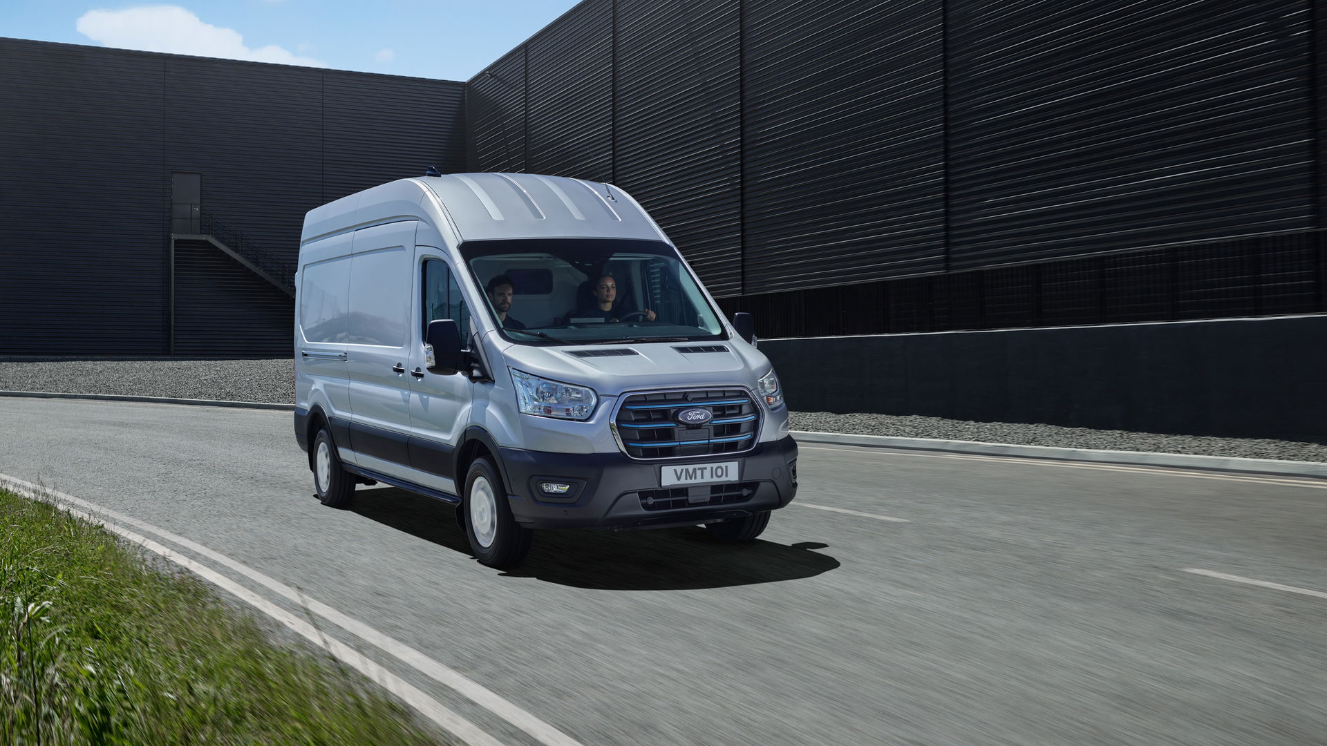Ford commercial van outside a modern dealership building