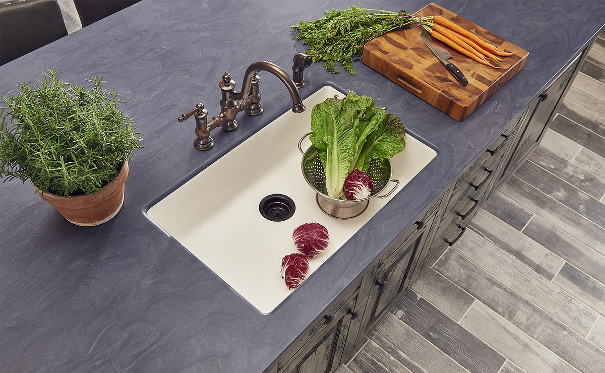 Encimera gris con fregadero y grifo instalados en una cocina.