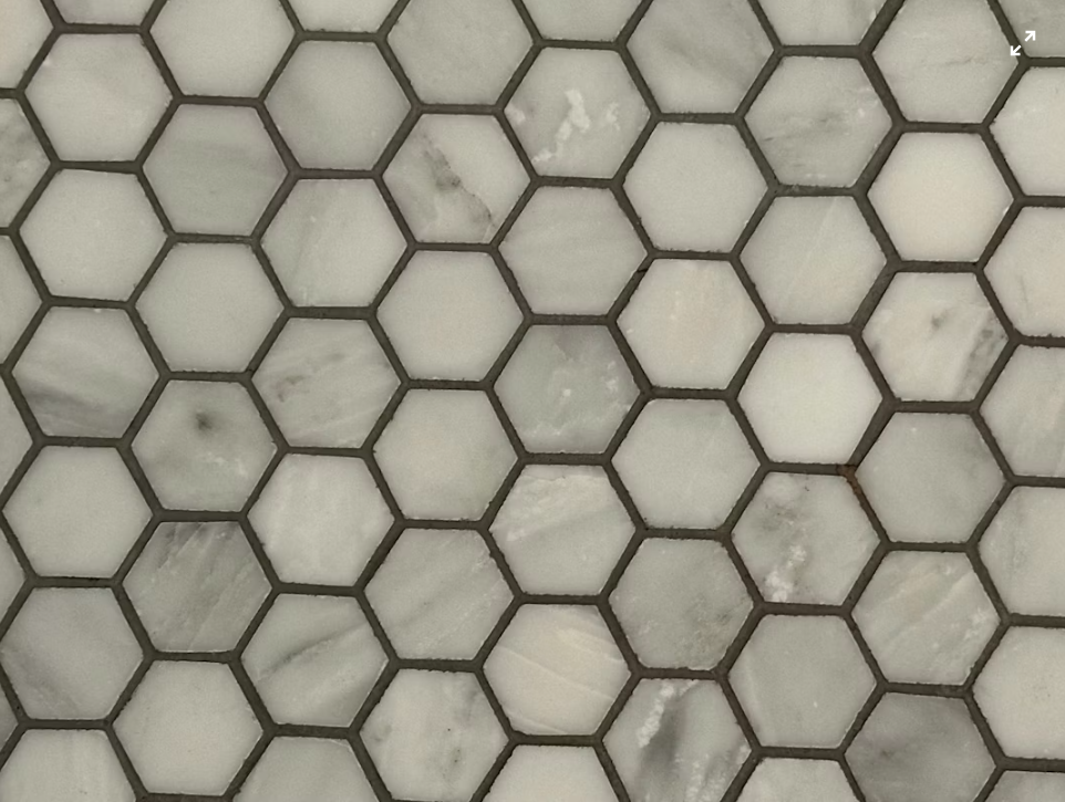 Baldosas hexagonales con juntas visibles, una de las superficies que Happy Habitat Cleaners limpia.