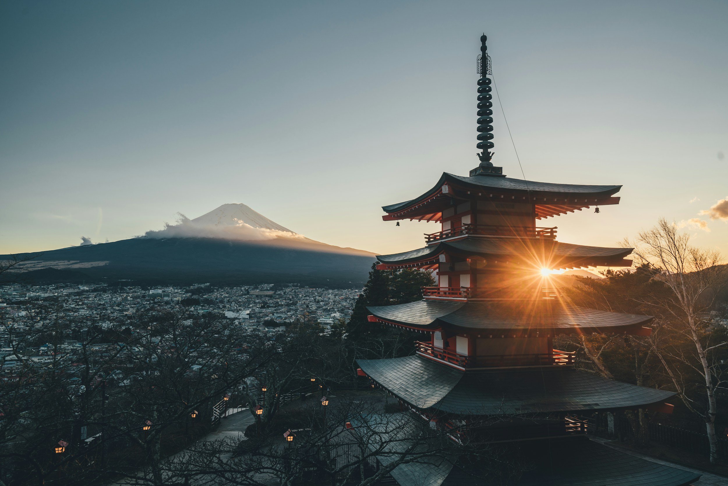 Pagoda japonesa al atardecer con el monte Fuji al fondo.