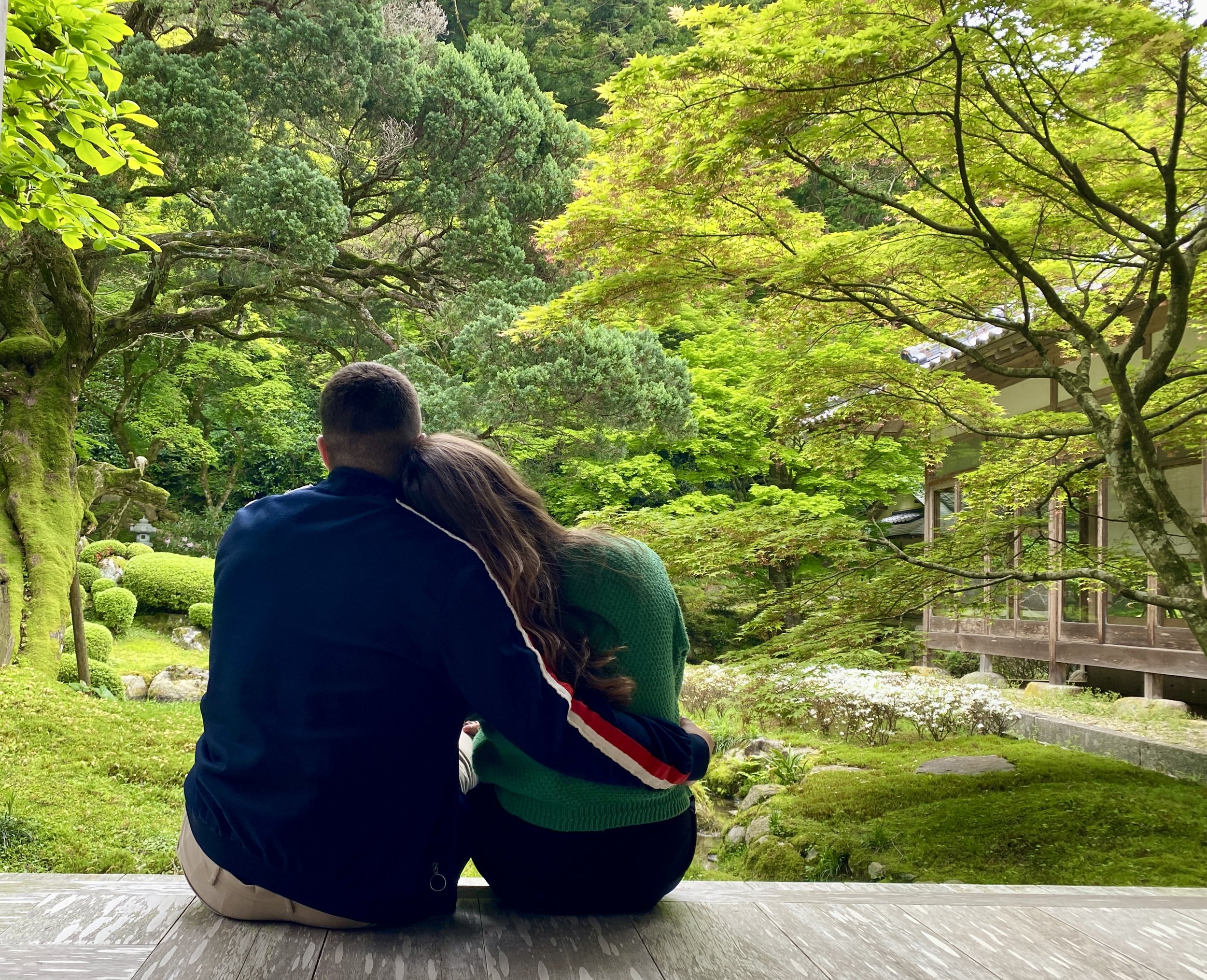 Pareja caminando por un sendero entre árboles en Japón.