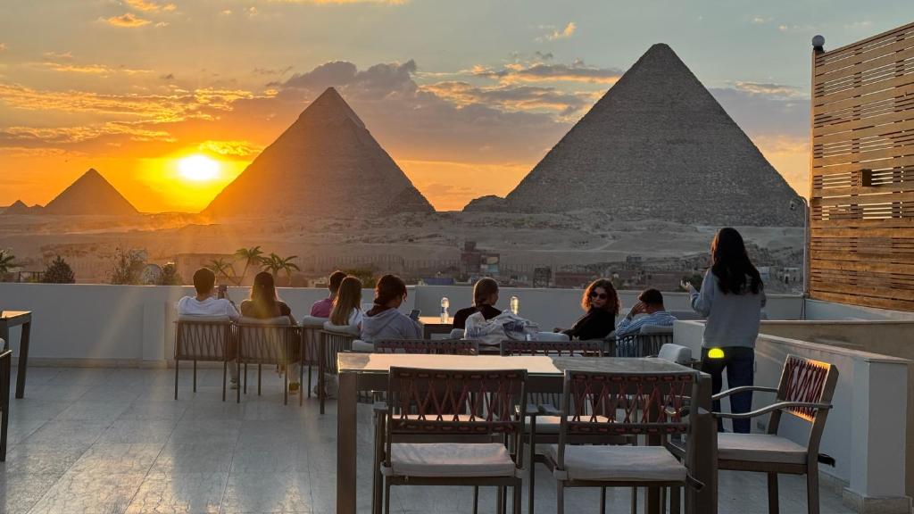 Comedor al aire libre con vistas a pirámides al atardecer.