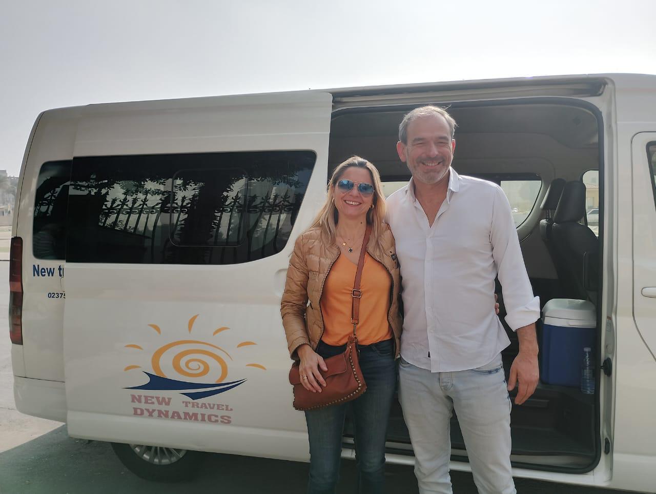 Dos personas junto a una furgoneta con la marca New Travel Dynamics.