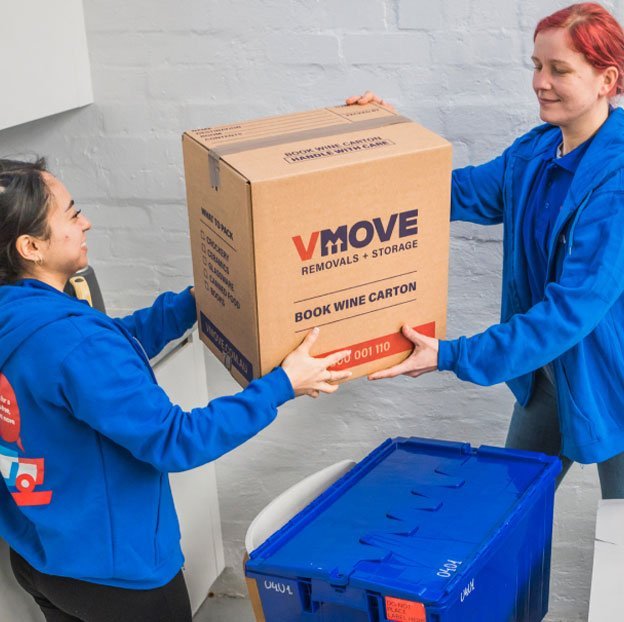 Trabajadores de Vmove mueven una caja identificada con la marca.