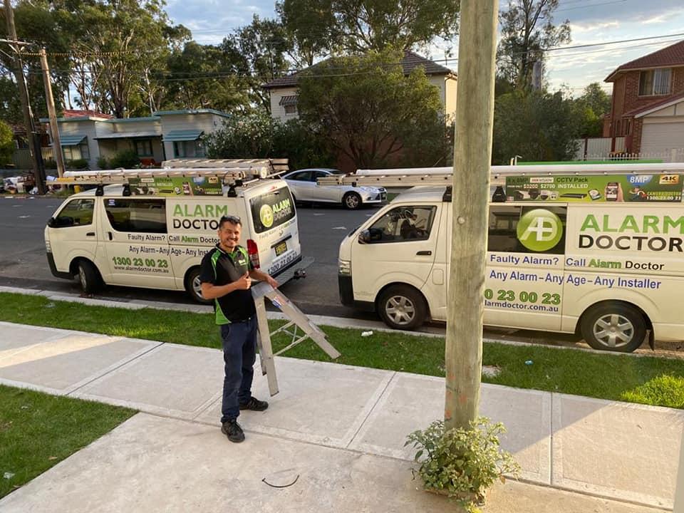 Técnico de Alarm Doctor junto a un vehículo de servicio con herramientas de seguridad.