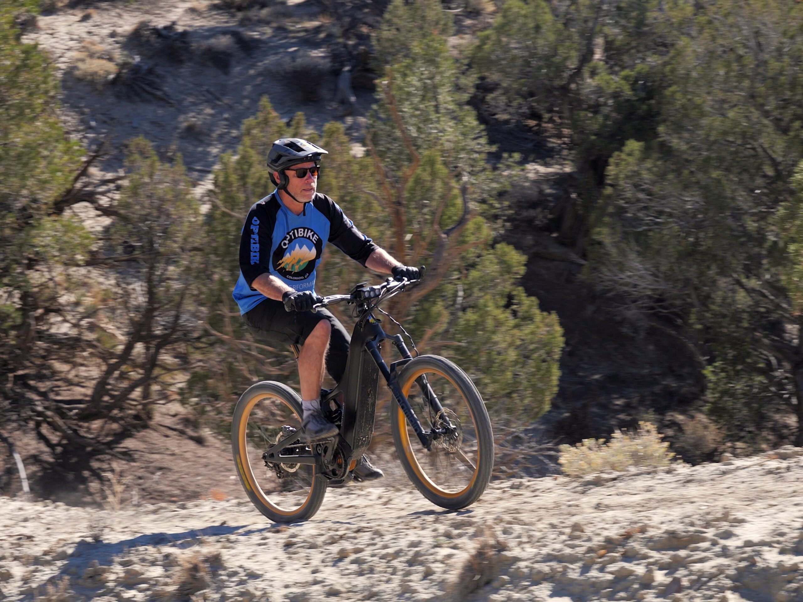Ciclista sube por un sendero rocoso con una bicicleta eléctrica Optibike.