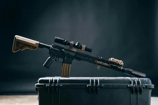 Rifle de precisión colocado sobre un estuche de transporte.