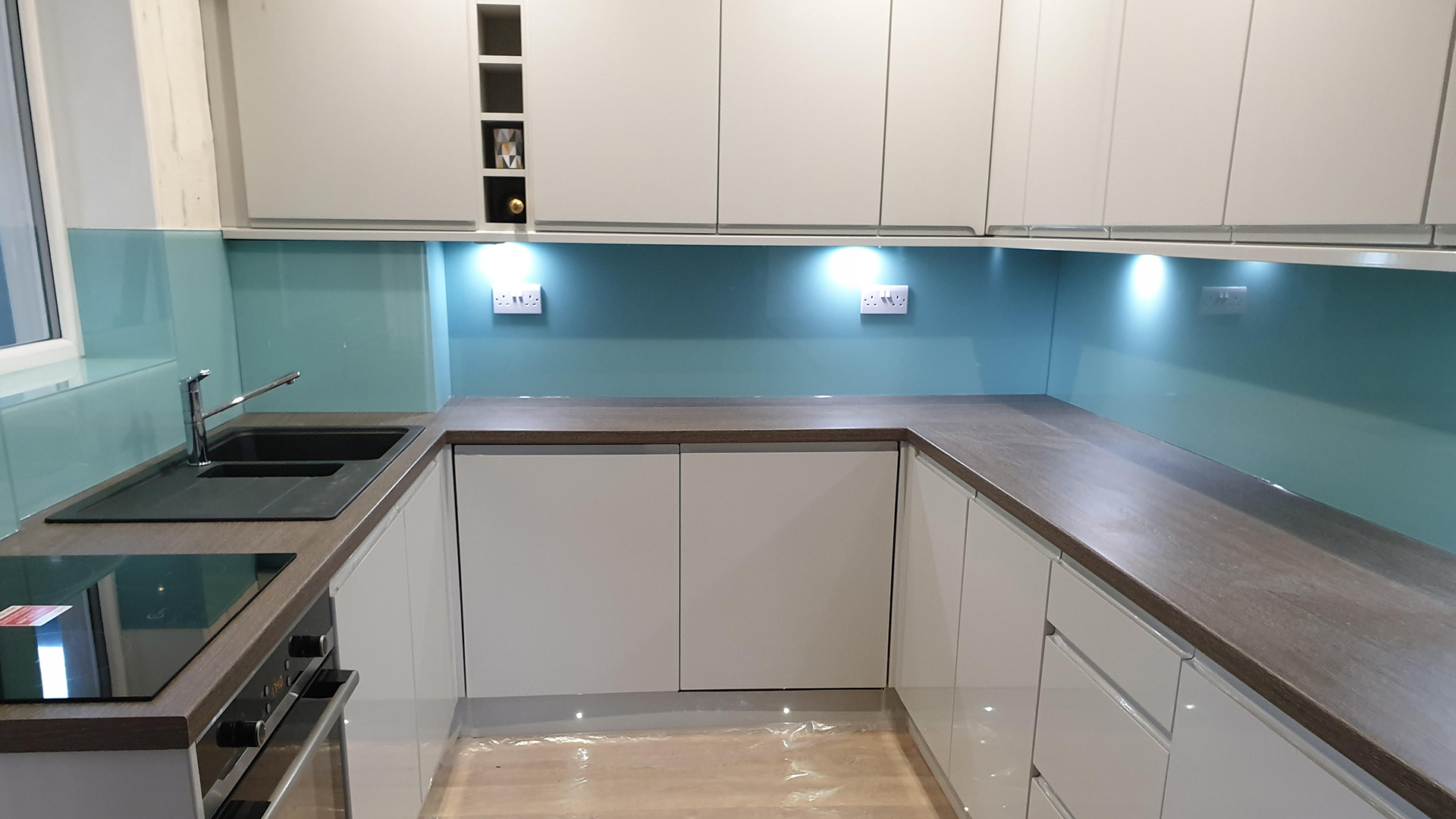 Paneles de vidrio azul en una cocina blanca. / Blue glass panels in a white kitchen.