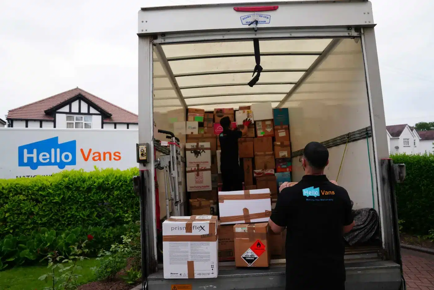 Trabajador carga cajas en una furgoneta de Hello Vans. / Worker loads boxes into a Hello Vans van.