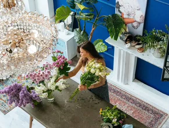 Florista preparando y organizando flores en una tienda / Florist preparing and arranging flowers in a shop