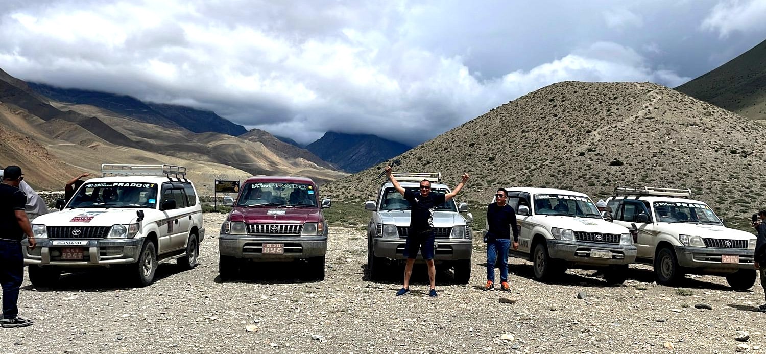 Vehículos todoterreno y personas en un paisaje montañoso de Nepal / Four-wheel-drive vehicles and people in a mountainous landscape in Nepal