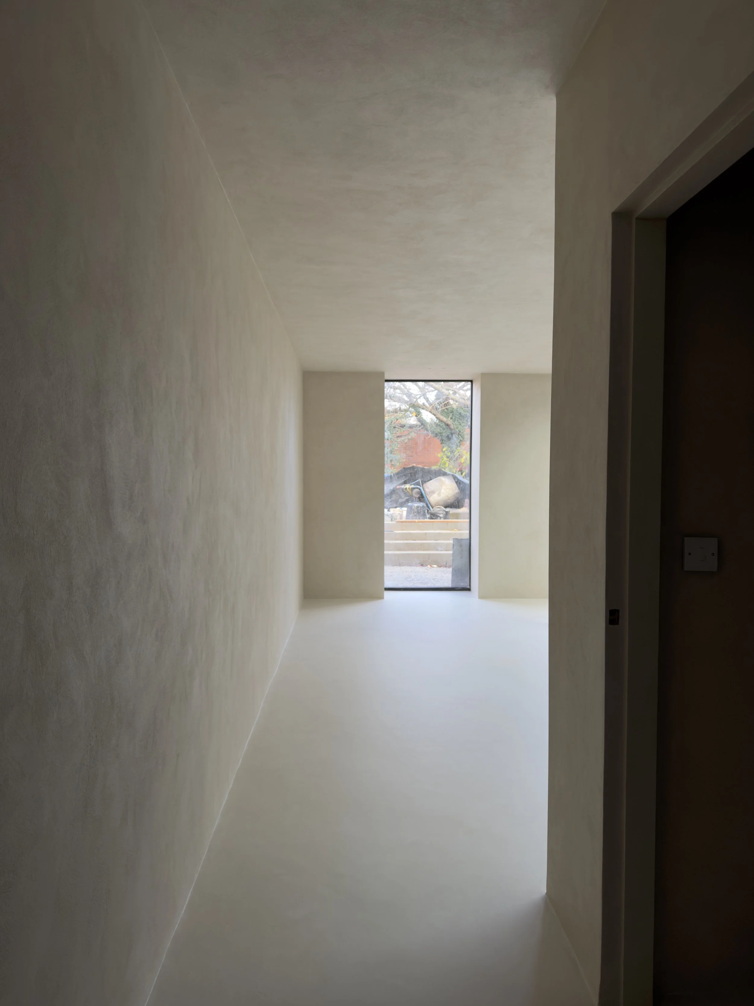 Pasillo terminado con paredes y piso de acabado continuo / Finished hallway with seamless walls and flooring.