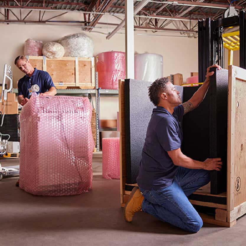Profesional envuelve y prepara mobiliario para su traslado. / A professional wraps and prepares furniture for transport.
