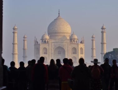 El Taj Mahal al fondo de la estación y un tren exprés en Agra.