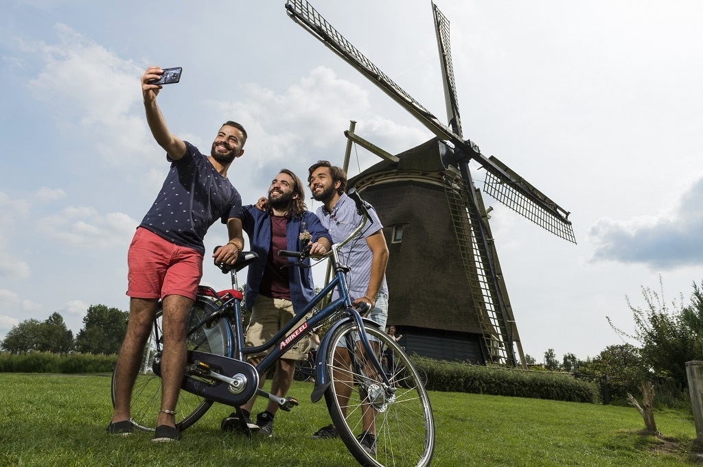 Excursión en bicicleta por el campo neerlandés junto a un molino