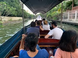 Pasajeros recorren los canales de Bangkok en un barco de cola larga
