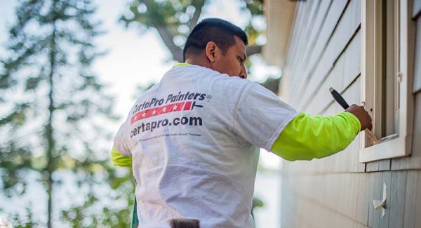 CertaPro painter applying paint to a house exterior