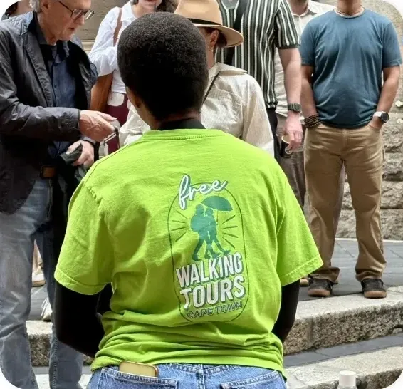 Guía con paraguas verde y visitantes durante una caminata por Ciudad del Cabo.