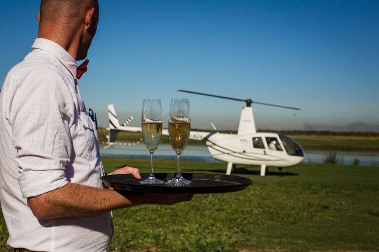 Servicio de vino junto a un helicóptero, imagen de la experiencia panorámica que publica Wine Flies.