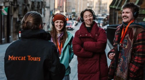 Guía de Mercat Tours con visitantes en Edimburgo