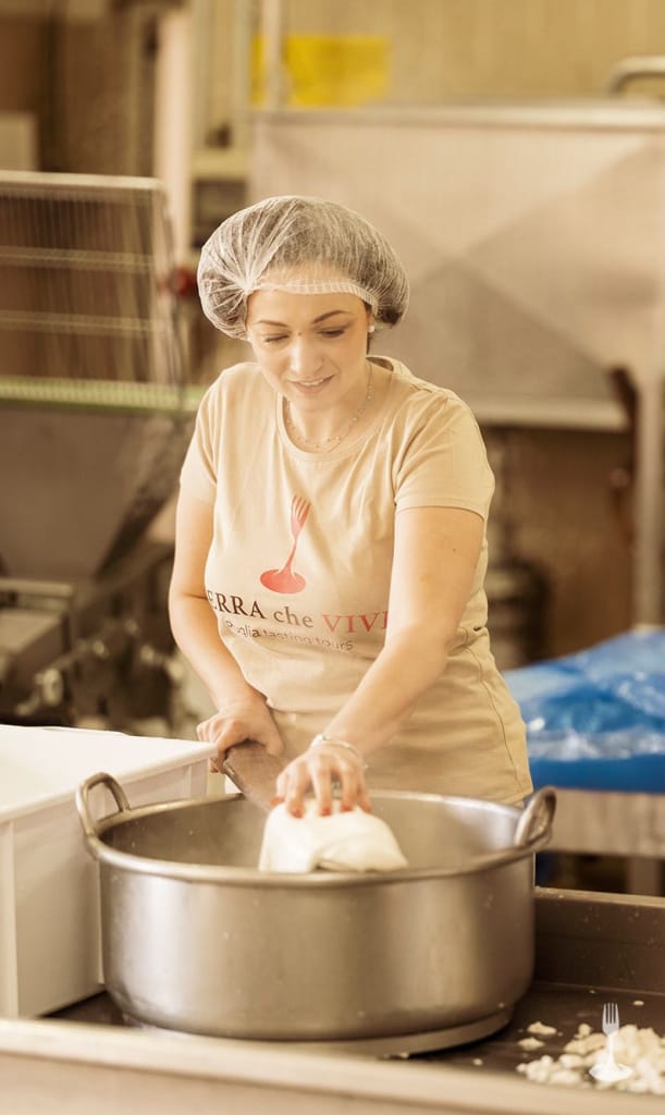 Preparazione artigianale di formaggio durante un’esperienza gastronomica in Puglia