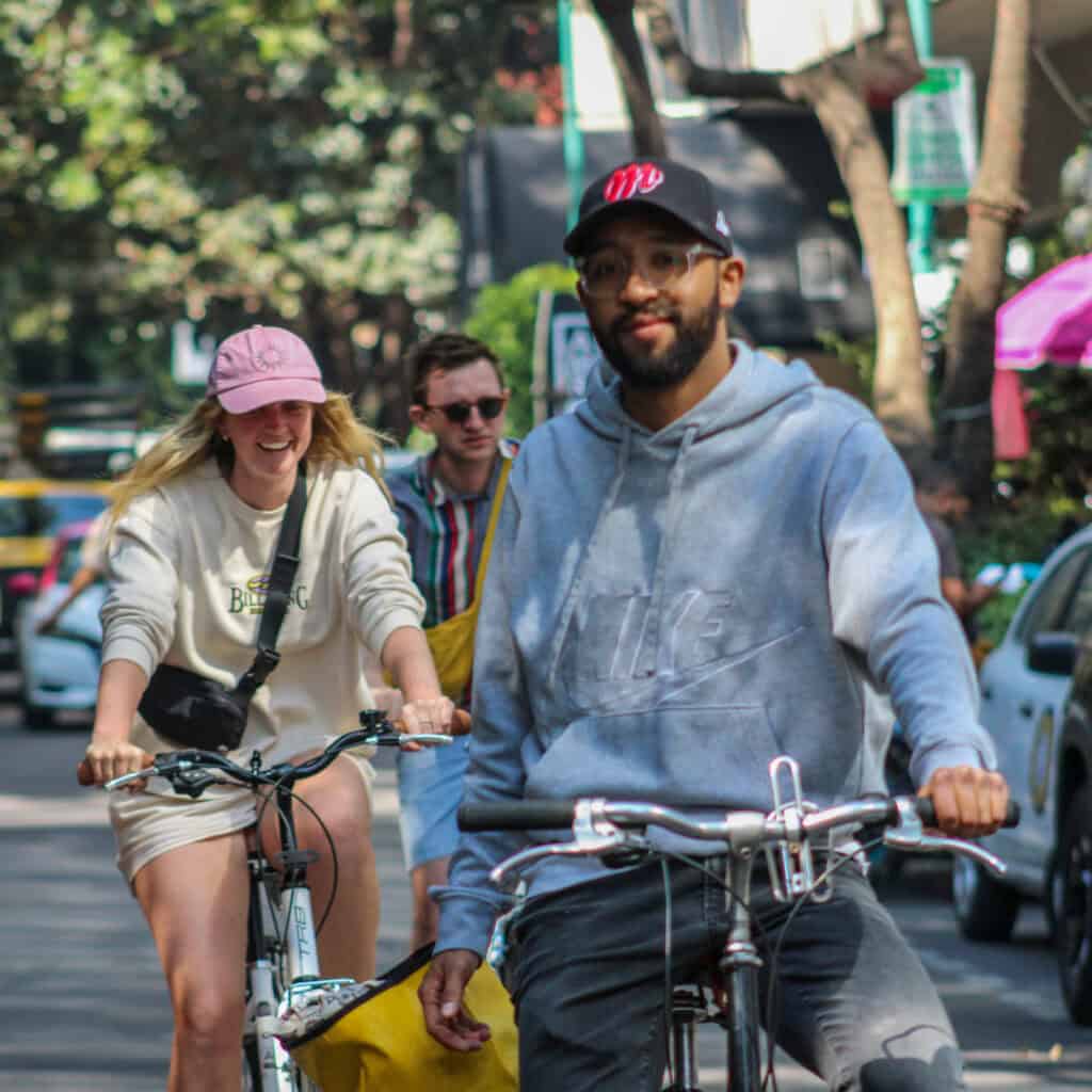 Participantes en bicicleta por una calle arbolada de Ciudad de México durante un tour de Food Hood