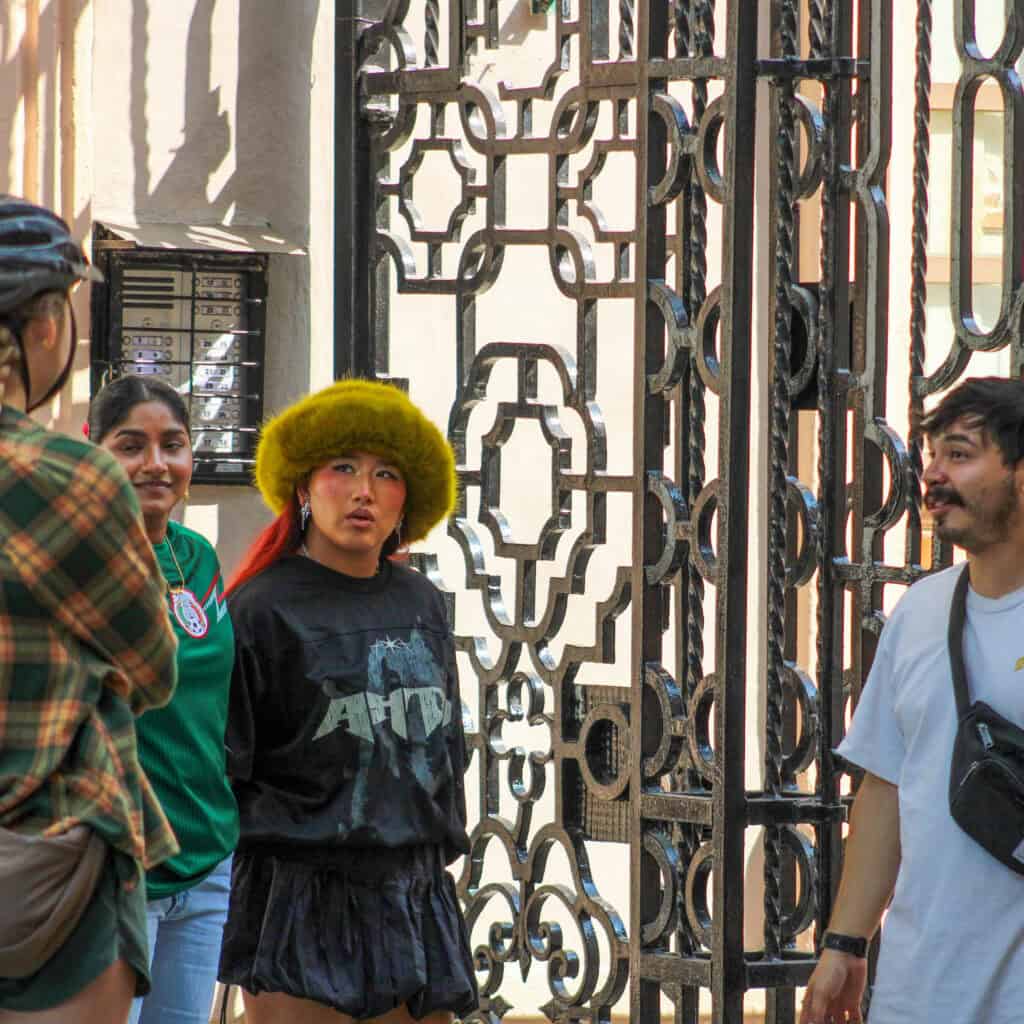 Guía conversa con participantes en una parada de un recorrido gastronómico por la ciudad
