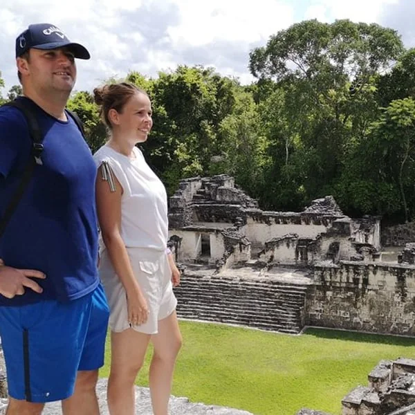 Guía acompaña a viajeros frente a una estructura de Tikal