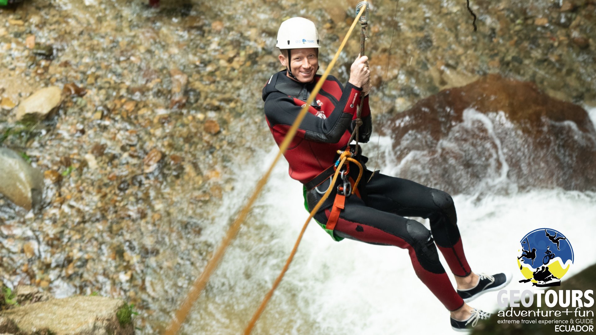 Guía desciende con cuerda por una cascada durante una actividad de canyoning