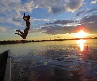 Viajero se lanza al agua durante una excursión de naturaleza en Cuyabeno