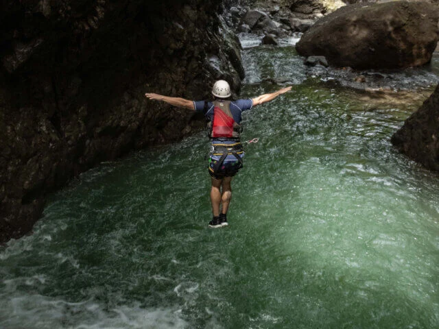 Salto a una poza durante una experiencia de cascadas de Desafío