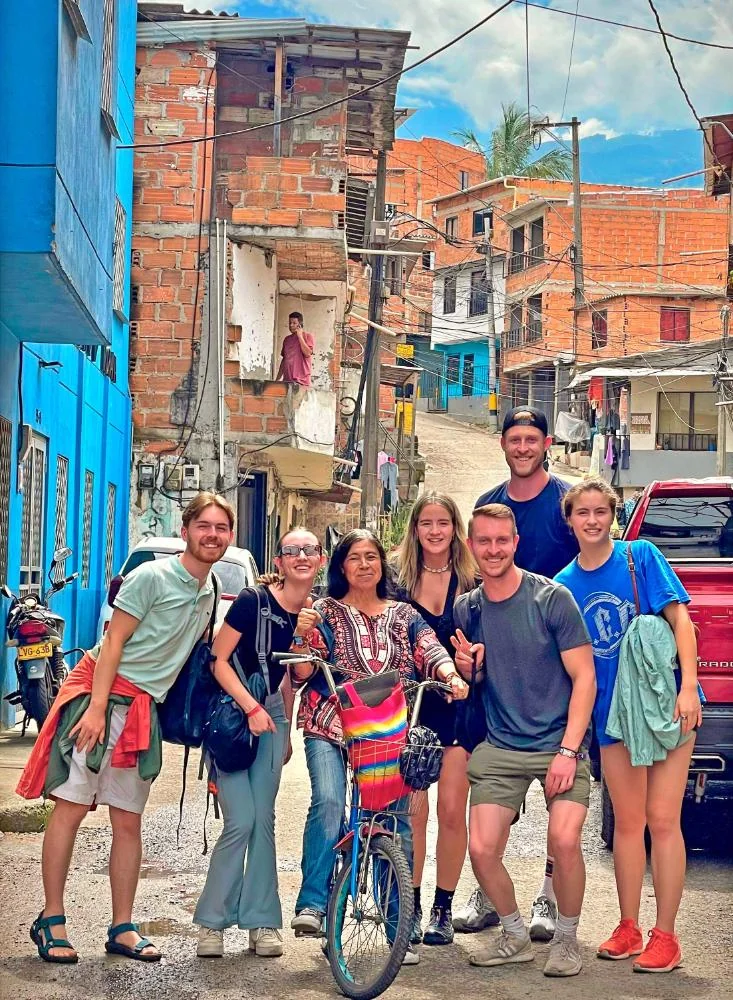 Guía acompaña a visitantes por una calle de barrio durante un recorrido de Real City Tours