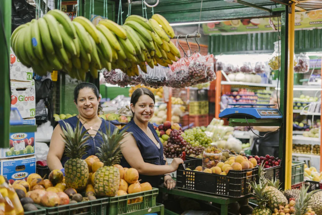 Vendedoras y frutas tropicales en una visita de mercado de Real City Tours