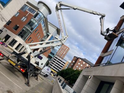 Operario realizando limpieza de ventanas en altura con una plataforma elevadora