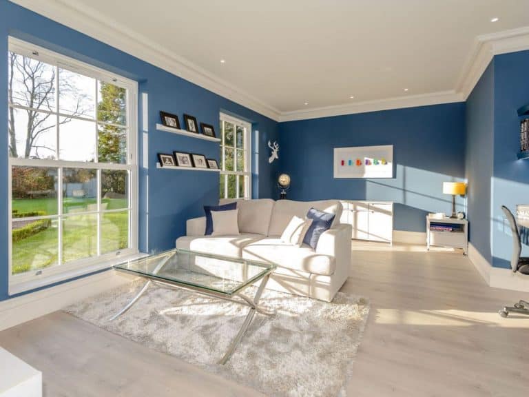 Interior luminoso con ventanas instaladas y vistas a un jardín. / Bright room with installed windows overlooking a garden.