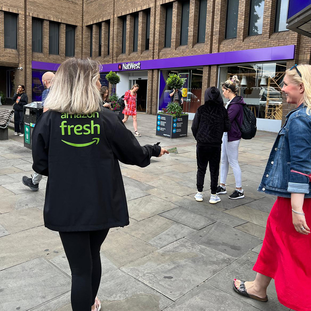 Promotional staff speaking with pedestrians on a city street