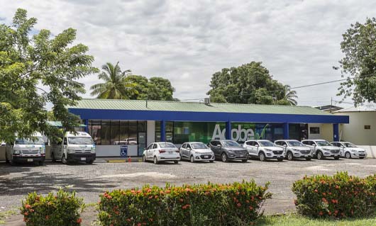 Vehículos estacionados frente a una oficina de Adobe Rent a Car