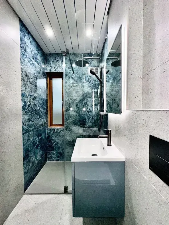 Ducha y lavabo en un baño reformado