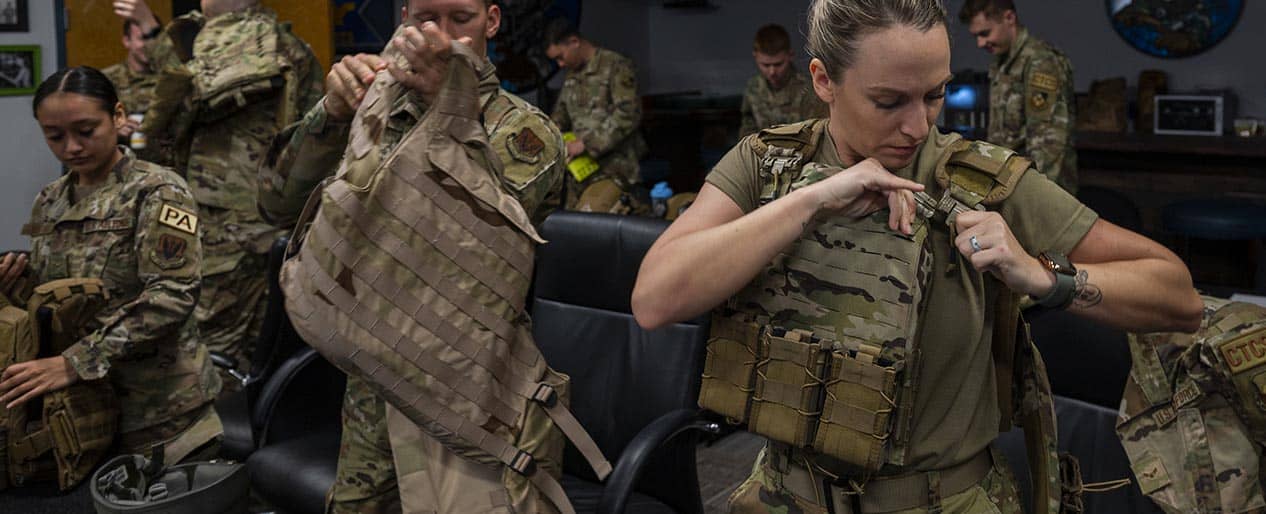 Service members checking tactical uniform equipment