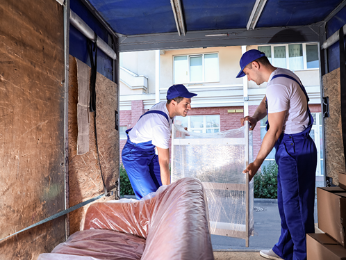 Movers loading wrapped furniture into a truck