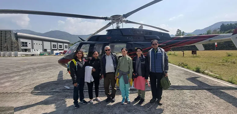 Travellers beside a charter helicopter promoted by Udan Aviation