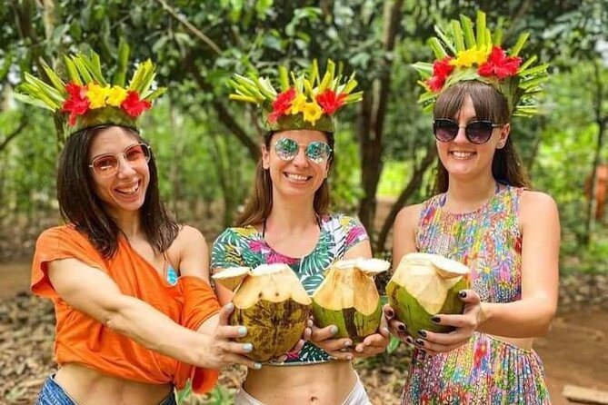 Visitantes con coronas de hojas y cocos durante una actividad en una finca de especias anunciada por Ameir Tours.