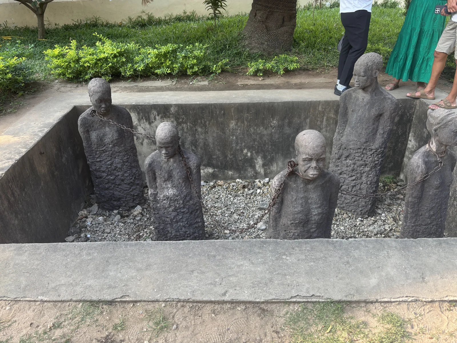 Monumento con figuras encadenadas en Stone Town, punto de interés histórico.