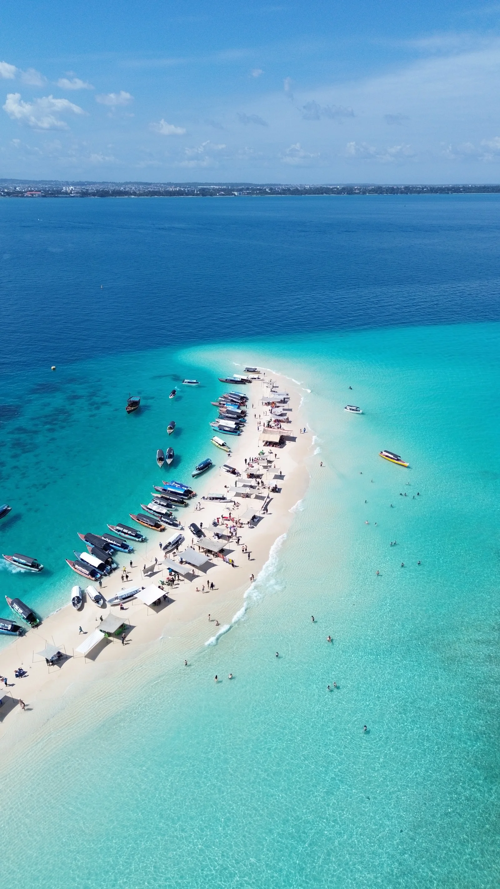 Banco de arena y embarcaciones en las aguas de Zanzíbar, paisaje de excursiones marítimas.